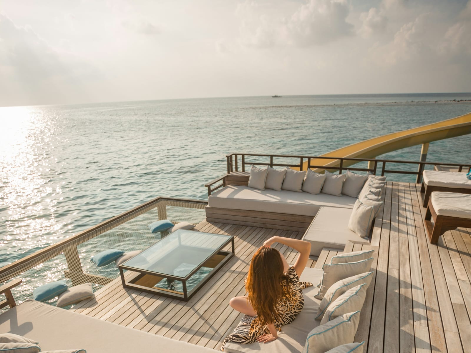 An open-air terrace above the sea at dusk